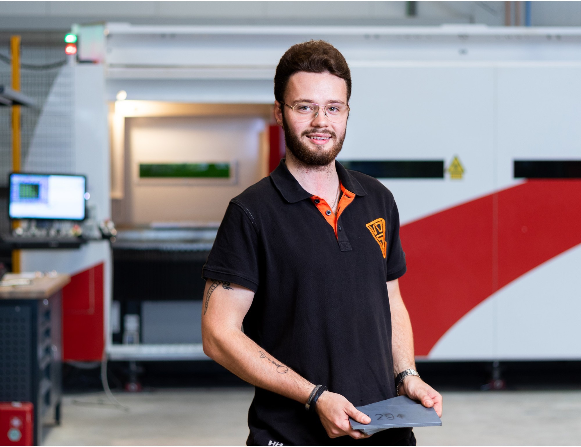 CNC-operator die voor de lasersnijmachine staat.